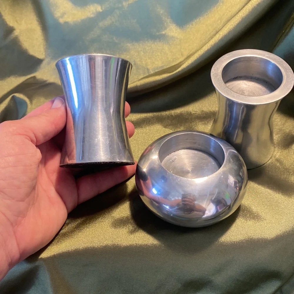 Three silvertone candleholders.